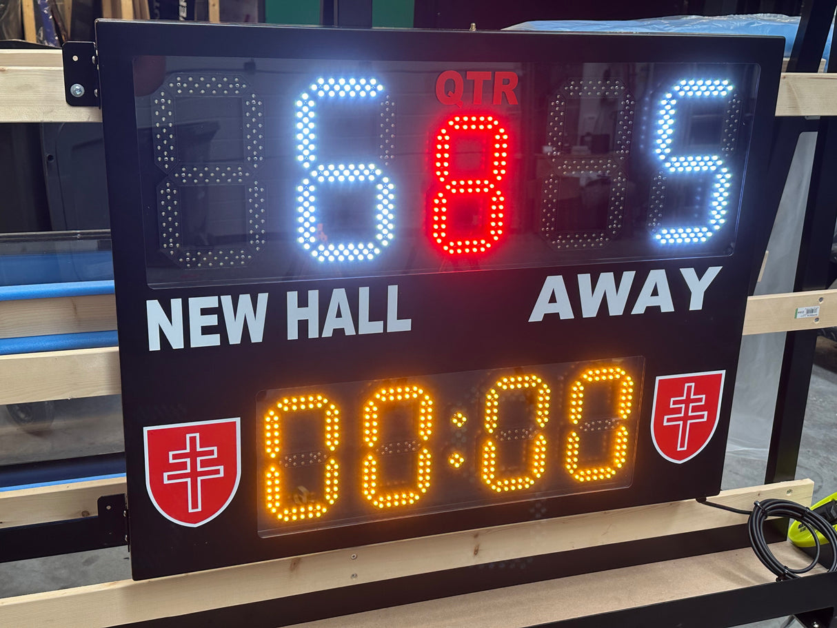 Digital scoreboard displaying game time and teams' names on a wooden surface.