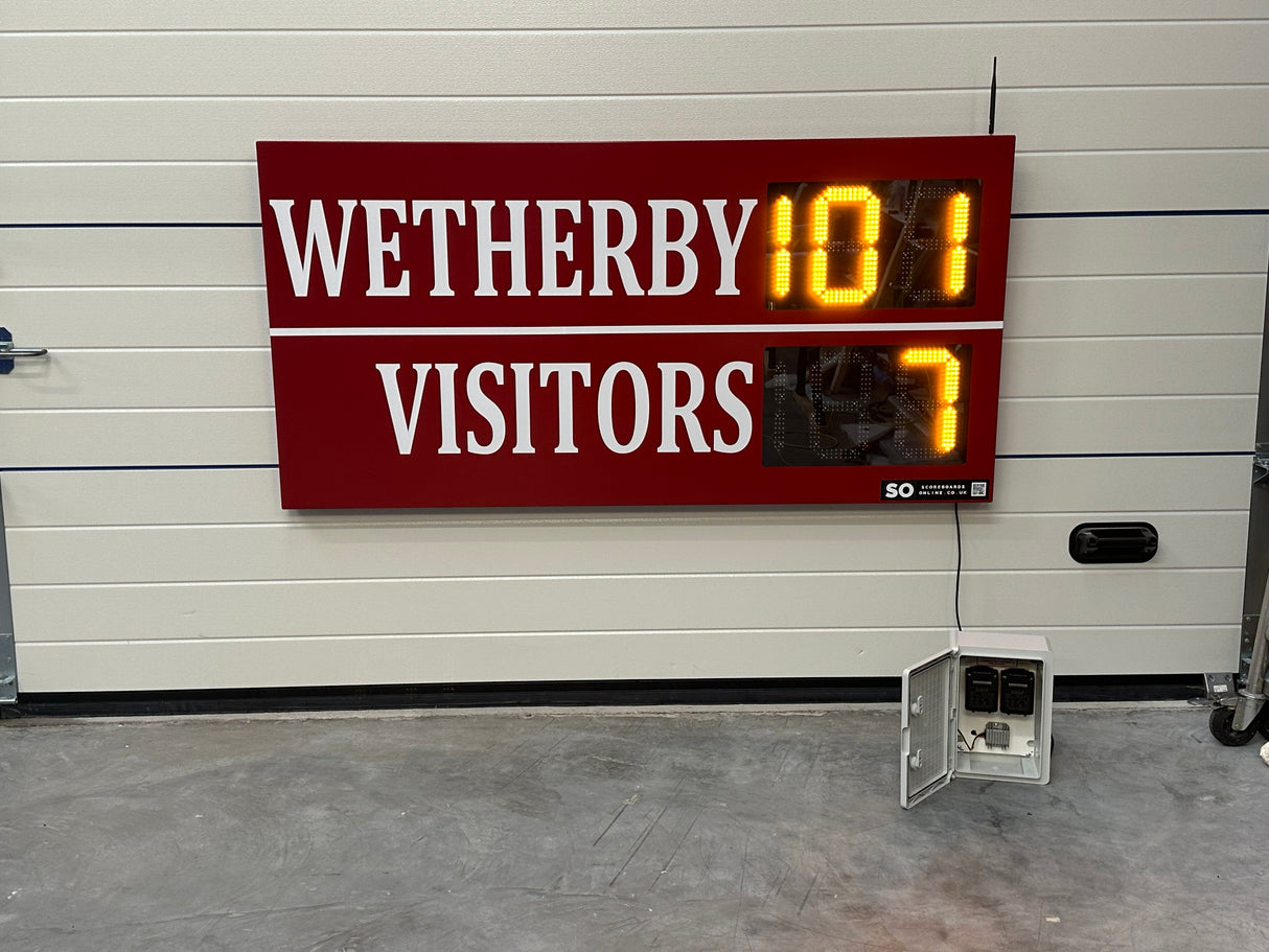 Digital LED scoreboard displaying 'Wetherby 101 Visitors 7' against a white wall. Personalised to include the club's colours.