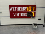 Digital LED scoreboard displaying 'Wetherby 101 Visitors 7' against a white wall. Personalised to include the club's colours.